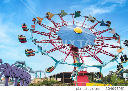 Scenery with rides in a vast amusement park in a resort area 104093961