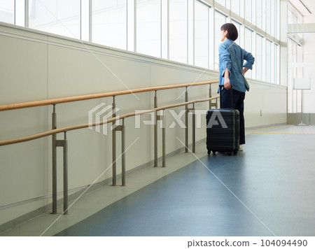 一位女士提著手提箱出門旅行的圖片 一位女士提著手提箱出門旅行的圖片 104094490