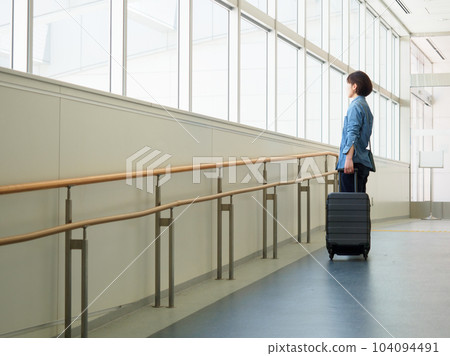 Image of a woman leaving for a trip with a suitcase Image of a woman leaving for a trip with a suitcase 104094491
