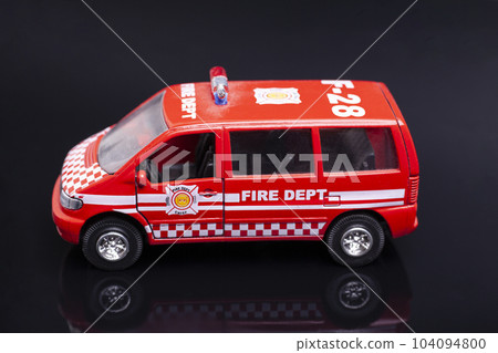fire dept car toy on black background. fire dept car toy on black background. 104094800