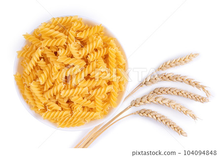 Raw pasta fusilli in bowl and wheat spikelets isolated on white background 104094848