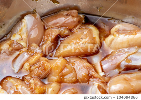 Fried chicken cooking scene. In order to season the chicken thighs, marinate them in the sauce. Fried chicken cooking scene. In order to season the chicken thighs, marinate them in the sauce. 104094866