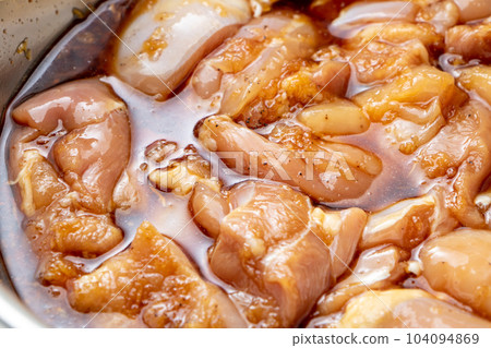 Fried chicken cooking scene. In order to season the chicken thighs, marinate them in the sauce. 104094869