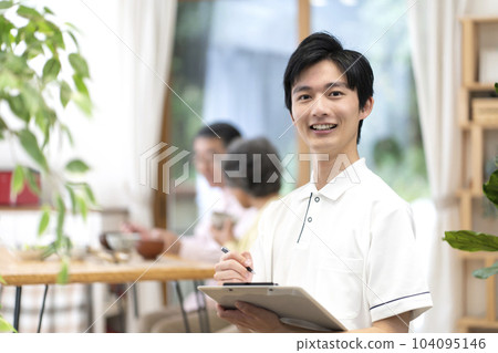 Young male caregiver writing records 104095146