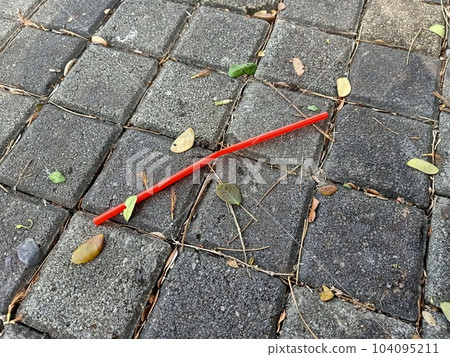 Used red straw on paving stones pavement  104095211