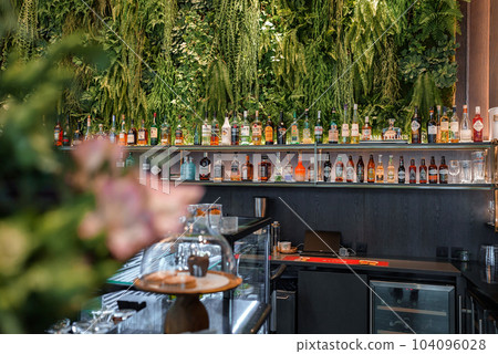 Eco architecture. Floral interior. Green cafe with plants. Urban environment concept. Ecology and green living in city. Modern restaurant covered green plant. 104096028