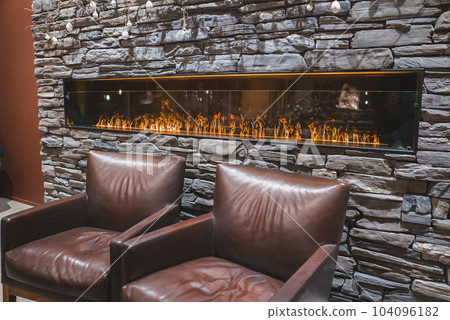 Beautiful luxury interior design with a long fireplace and sofas. Luxury hotel interior design. Beautiful luxury interior design with a long fireplace and sofas. Luxury hotel interior design. 104096182