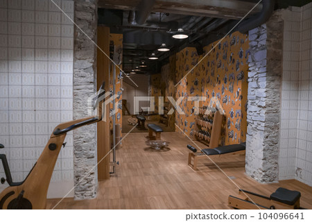 Pendant lights hanging on ceiling over dumbbells and abdominal bench in exercise room at luxury hotel, luxury travel and fitness concept for tourists Pendant lights hanging on ceiling over dumbbells and abdominal bench in exercise room at luxury hotel, luxury travel and fitness concept for tourists 104096641