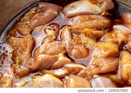 Fried chicken cooking scene. In order to season the chicken thighs, marinate them in the sauce. Fried chicken cooking scene. In order to season the chicken thighs, marinate them in the sauce. 104097060
