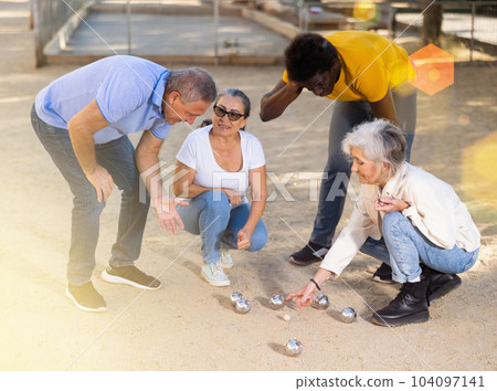 Mature people playing petanque on sand together 104097141