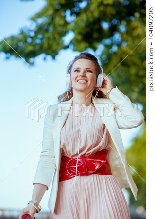 smiling stylish 40 years old woman in dress and jacket in city smiling stylish 40 years old woman in dress and jacket in city 104097206