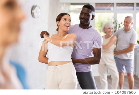 Young girl dancing merengue with African American partner 104097600