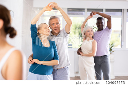 Mature male novice student of fitness studio practices paired Latin American rumba dance 104097653