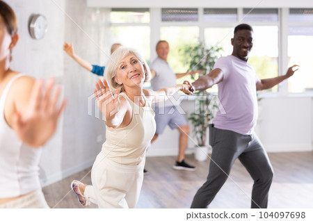 Mature men and women practicing Rock 'n' Roll dance in training hall Mature men and women practicing Rock 'n' Roll dance in training hall 104097698