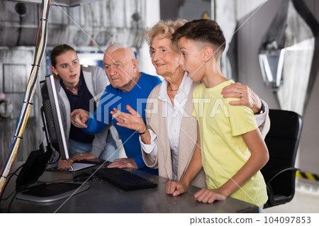Grandmother, grandfather and kids in escape room 104097853