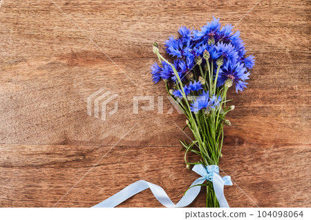 Blue cornflowers, bouquet picked in summer on wooden background. Blue cornflowers, bouquet picked in summer on wooden background. 104098064