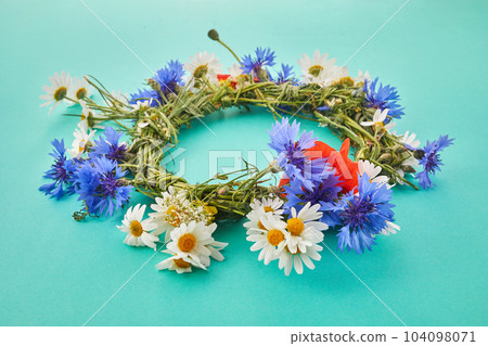 Wreath of chamomile flower on green background. Midsummer holiday background Wreath of chamomile flower on green background. Midsummer holiday background 104098071