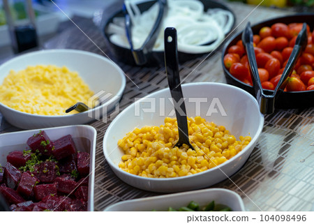 Salad bar. Salad buffet at restaurant. Fresh salad bar buffet for lunch. Healthy eating. Corn and purple sweet potato in bowl on counter. Vegetarian food. Self-service salad station in the restaurant. 104098496