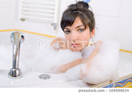 Young brunette woman in the bathtub Young brunette woman in the bathtub 104099034