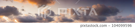 panorama of a sky in warm evening light. massive clouds in orange color at sunset 104099596