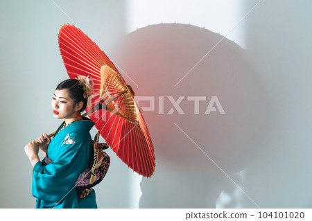 A woman in a kimono holding a Japanese umbrella 104101020
