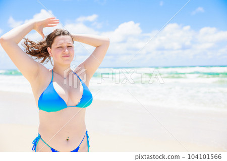 Caucasian woman in a swimsuit with her hair tied up Caucasian woman in a swimsuit with her hair tied up 104101566