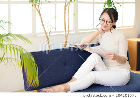 Middle woman in eyeglasses looking at pamphlet Middle woman in eyeglasses looking at pamphlet 104101575
