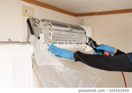 Hand of a male worker cleaning the air conditioner Hand of a male worker cleaning the air conditioner 104101649