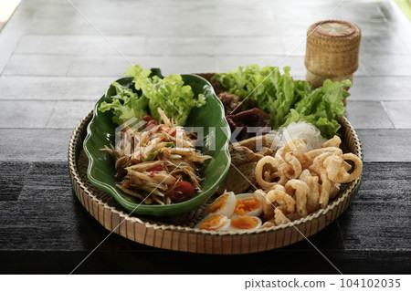 Som tum Papaya salad with pork crackling, eggs, vegetable, and sticky rice 104102035