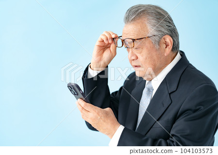 Senior man looking at smartphone Presbyopia 104103573