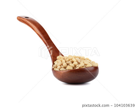 Wooden spoon with shelled pine nuts on a white background.Wooden spoon full of shelled pine nuts on a white background. 104103639