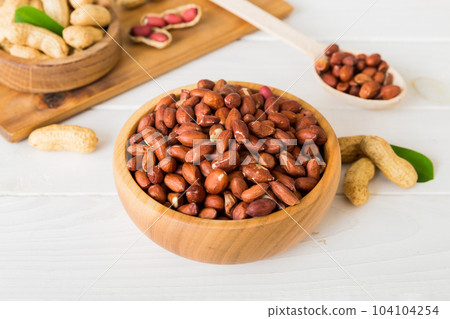 Fresh healthy peanuts in bowl on colored table background. Top view Healthy eating bertholletia concept. Super foods 104104254