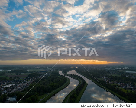Aerial view of a colorful dramatic sunrise sky over the river Nete in Duffel, Belgium. River with 104104624
