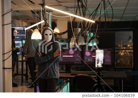 Online hacker filming live ransomware video on smartphone, threatening to expose government information. Anonymous spy hacking database system with trojan virus, breaking encryption. 104106839