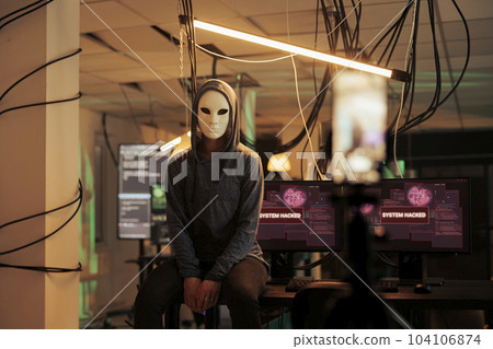 Hacker breaking into computer system, attacking database. Cybercrime, anonymous woman stealing information, programming online malware software at night time, looking at camera Hacker breaking into computer system, attacking database. Cybercrime, anonymous woman stealing information, programming online malware software at night time, looking at camera 104106874