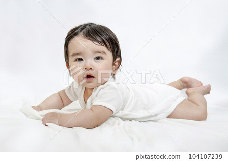 Side view of a baby crawling while looking at the camera 104107239