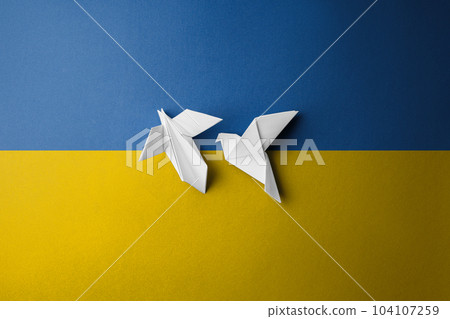 two white paper birds on yellow blue background 104107259