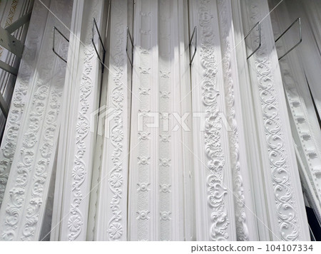 ceiling cornices, different types of white foam plastic ceiling moldings at store showcase, demonstration stand samples, showroom ceiling cornices, different types of white foam plastic ceiling moldings at store showcase, demonstration stand samples, showroom 104107334