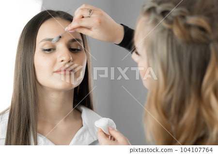 Image conveys energy and creativity eyebrow designer, works expressiveness eyebrows and adds freshness and youth to woman's face. Beautician works in beauty salon as professional makeup artist Image conveys energy and creativity eyebrow designer, works expressiveness eyebrows and adds freshness and youth to woman's face. Beautician works in beauty salon as professional makeup artist 104107764