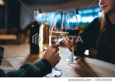 two person cheering and celebrate and drink red and white wine in restaurant two person cheering and celebrate and drink red and white wine in restaurant 104108491