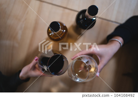 two person cheering and celebrate and drink red and white wine in restaurant two person cheering and celebrate and drink red and white wine in restaurant 104108492