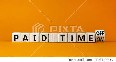 Paid time off or on symbol. Turned a wooden cube and changed words 'paid time on' to 'paid time off'. Beautiful orange background. Business and paid time off or on concept, copy space. Paid time off or on symbol. Turned a wooden cube and changed words 'paid time on' to 'paid time off'. Beautiful orange background. Business and paid time off or on concept, copy space. 104108839