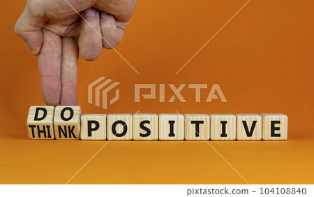 Think and do positive symbol. Businessman turns wooden cubes and changes words think positive to do positive. Beautiful orange background. Business, think and do positive concept. Copy space. 104108840