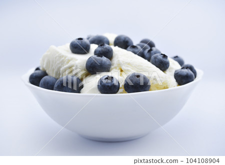 Ice cream with berries. Ice cream in a ceramic bowl. Ice cream and blueberries. 104108904