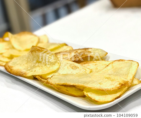 Potatoes fries in the white plate isolated on the table. 104109059