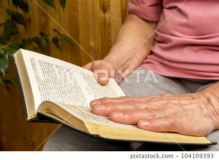 Senior women hands reading book Senior women hands reading book 104109393