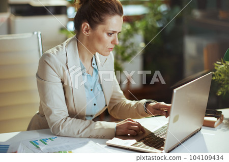 accountant woman in light business suit in green office 104109434