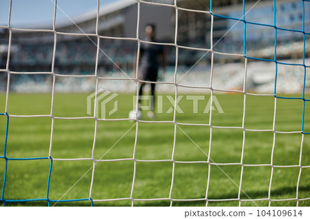 Young african american man holding soccer ball against soccer goal net Young african american man holding soccer ball against soccer goal net 104109614
