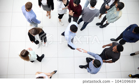 group of different business people passing in the office lobby. 104109689
