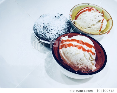 Three bowls with ice cream served in a restaurant,  104109748